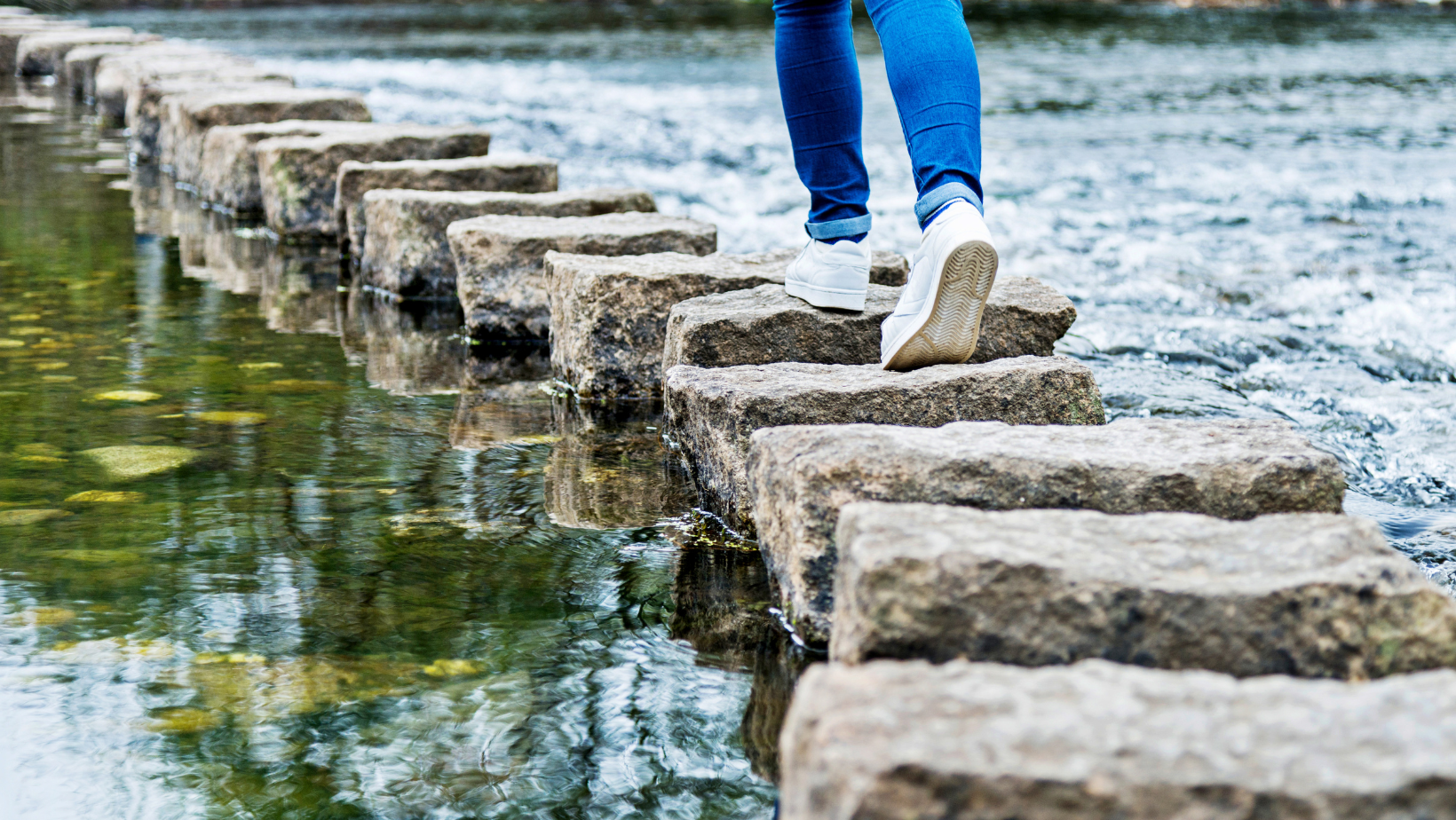 woman walking on stepping stones, suggesting she is moving away from Ozempic and choosing fact over fiction