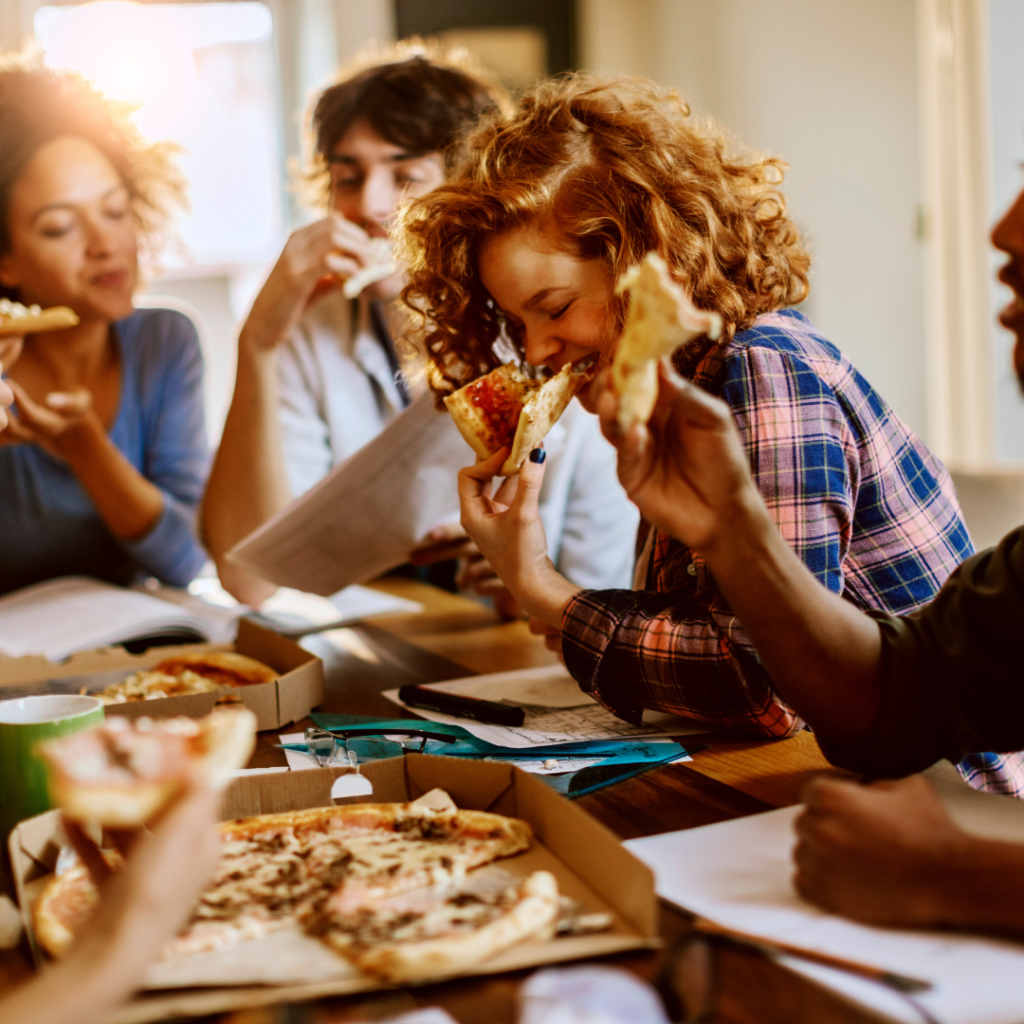 A group of friends enjoying eating pizza together.